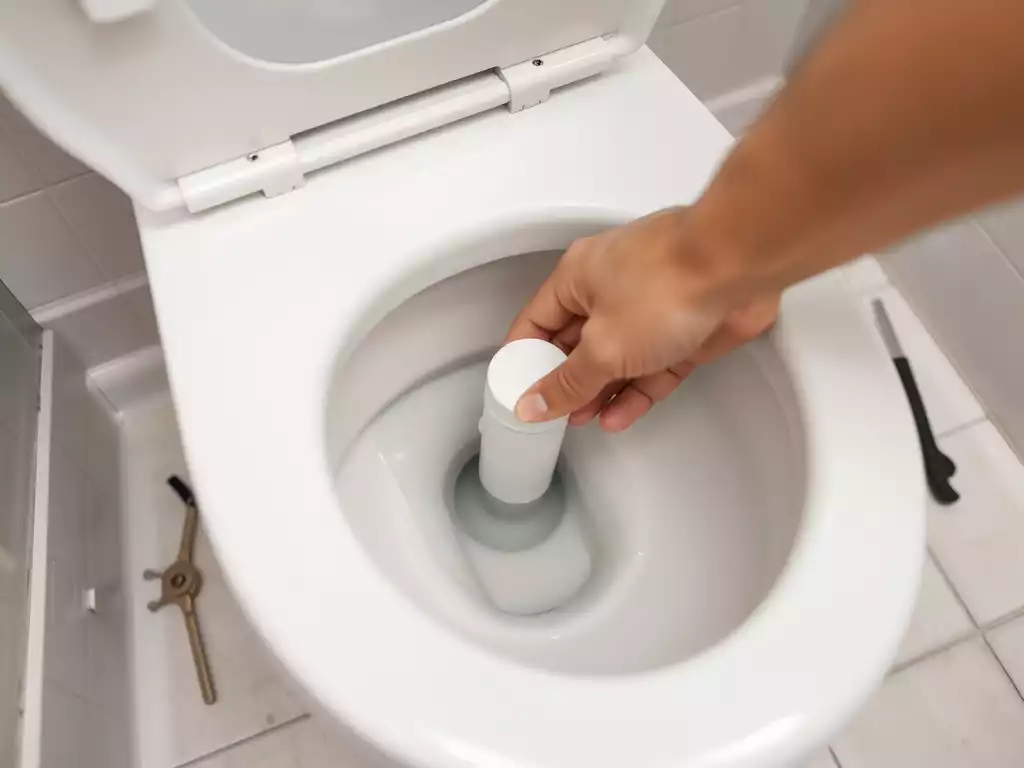 Person's hand adjusting a toilet float, demonstrating maintenance